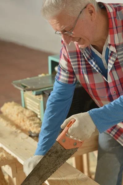 Hombre mayor reparando en la habitación Imágenes de stock libres de derechos