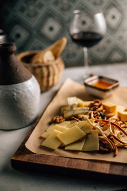 Tahtada peynir tabağı, üzümlü ve fındıklı, masada bal, yakın görüş. 