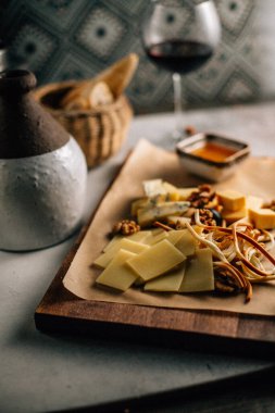 Tahtada peynir tabağı, üzümlü ve fındıklı, masada bal, yakın görüş. 