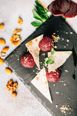 Fındık ve maydanozlu kara taş tahtada pancar topları ve pide ekmeği, yakın görüş. 