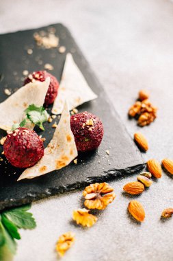 Fındık ve maydanozlu kara taş tahtada pancar topları ve pide ekmeği, yakın görüş. 