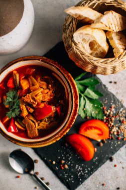 Lezzetli Ukrayna borş çorbası kasede ve ekmek dilimleri koyu taş tabakta, yakın görüş 