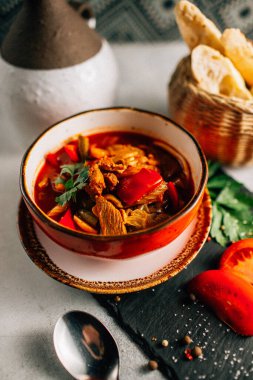 Lezzetli Ukrayna borş çorbası kasede ve ekmek dilimleri koyu taş tabakta, yakın görüş 