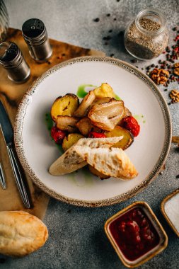 Kızarmış et, patates ve sebzeyle birlikte beyaz tabakta ekmek, yakın görüş 