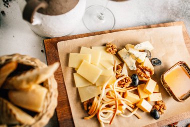 Tahtada peynir tabağı, üzümlü ve fındıklı, masada bal, yakın görüş. 