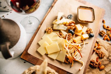 Tahtada peynir tabağı, üzümlü ve fındıklı, masada bal, yakın görüş. 