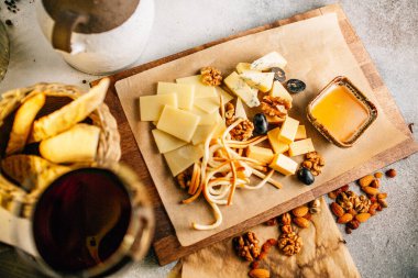 Tahtada peynir tabağı, üzümlü ve fındıklı, masada bal, yakın görüş. 