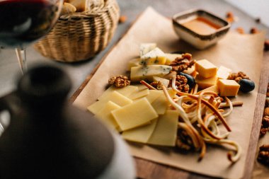 Tahtada peynir tabağı, üzümlü ve fındıklı, masada bal, yakın görüş. 
