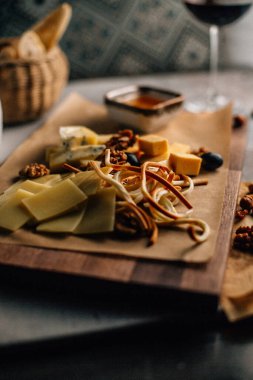 Tahtada peynir tabağı, üzümlü ve fındıklı, masada bal, yakın görüş. 