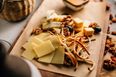 Tahtada peynir tabağı, üzümlü ve fındıklı, masada bal, yakın görüş. 