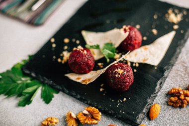 Fındık ve maydanozlu kara taş tahtada pancar topları ve pide ekmeği, yakın görüş. 