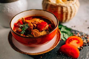 Lezzetli Ukrayna borş çorbası kasede ve ekmek dilimleri koyu taş tabakta, yakın görüş  