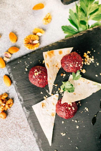 Fındık ve maydanozlu kara taş tahtada pancar topları ve pide ekmeği, yakın görüş. 