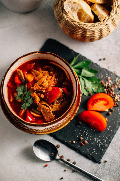 Lezzetli Ukrayna borş çorbası kasede ve ekmek dilimleri koyu taş tabakta, yakın görüş  