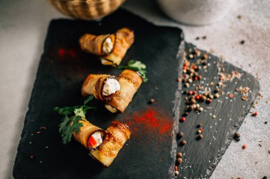 Kayalıklarda peynirli patlıcan ruloları, yakın görüş. 