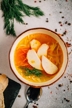 Tavuk çorbası ve dereotlu kase ve masada kaşık, yakın görüş. 