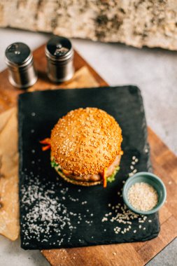 Koyu taş tabakta taze lezzetli bir hamburger, yakın görüş. 