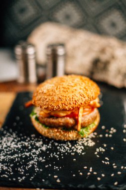 Koyu taş tabakta taze lezzetli bir hamburger, yakın görüş. 