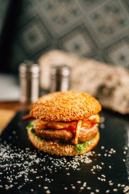 Koyu taş tabakta taze lezzetli bir hamburger, yakın görüş. 