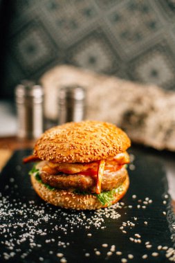 Koyu taş tabakta taze lezzetli bir hamburger, yakın görüş. 