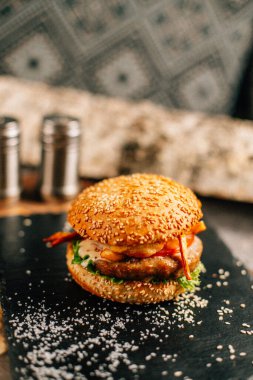 Koyu taş tabakta taze lezzetli bir hamburger, yakın görüş. 