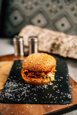 Koyu taş tabakta taze lezzetli bir hamburger, yakın görüş. 