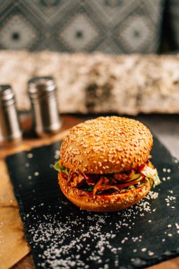 Koyu taş tabakta taze lezzetli bir hamburger, yakın görüş. 