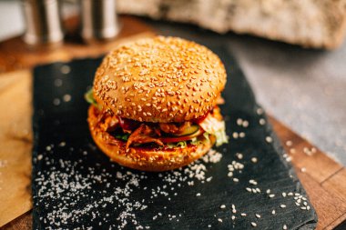 Koyu taş tabakta taze lezzetli bir hamburger, yakın görüş. 