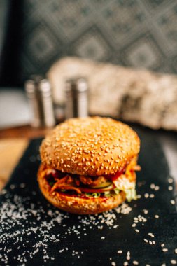 Koyu taş tabakta taze lezzetli bir hamburger, yakın görüş. 