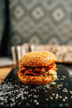 Koyu taş tabakta taze lezzetli bir hamburger, yakın görüş. 