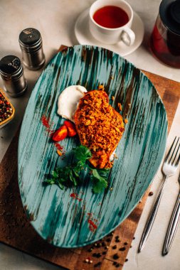 Lezzetli kızarmış et ve ekşi krema soslu vişneli domates ve bir fincan çay ve çaydanlık ile maydanoz. 