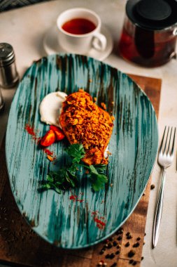 Lezzetli kızarmış et ve ekşi krema soslu vişneli domates ve bir fincan çay ve çaydanlık ile maydanoz. 