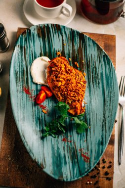 Lezzetli kızarmış et ve ekşi krema soslu vişneli domates ve bir fincan çay ve çaydanlık ile maydanoz. 