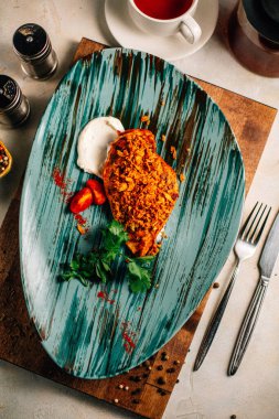 Lezzetli kızarmış et ve ekşi krema soslu vişneli domates ve bir fincan çay ve çaydanlık ile maydanoz. 