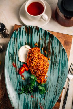 Lezzetli kızarmış et ve ekşi krema soslu vişneli domates ve bir fincan çay ve çaydanlık ile maydanoz. 