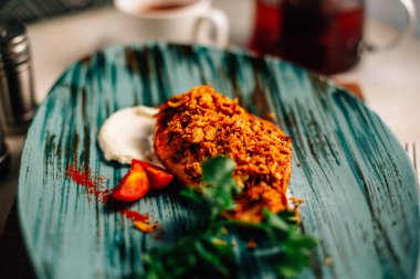 Lezzetli kızarmış et ve ekşi krema soslu vişneli domates ve bir fincan çay ve çaydanlık ile maydanoz. 