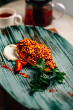 Lezzetli kızarmış et ve ekşi krema soslu vişneli domates ve bir fincan çay ve çaydanlık ile maydanoz. 