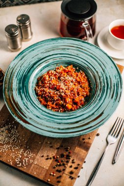 Sebze yahnili tabak ve tahtadan kesme tahtasına susam tohumlu yulaf ezmesi, yakın görüş. 