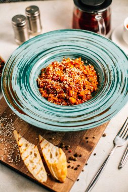 Sebze yahnili tabak ve tahtadan kesme tahtasına susam tohumlu yulaf ezmesi, yakın görüş. 