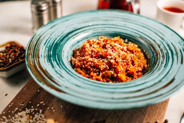 Sebze yahnili tabak ve tahtadan kesme tahtasına susam tohumlu yulaf ezmesi, yakın görüş. 