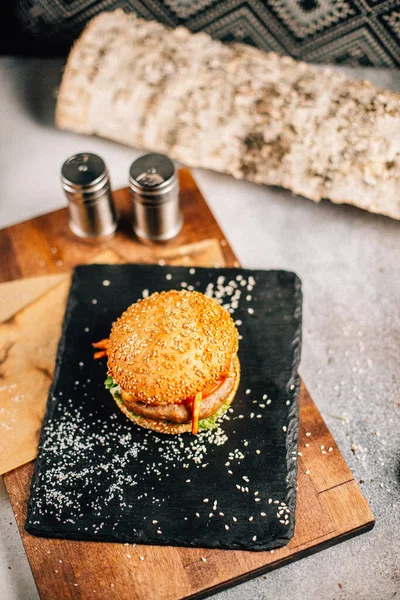 Koyu taş tabakta taze lezzetli bir hamburger, yakın görüş. 