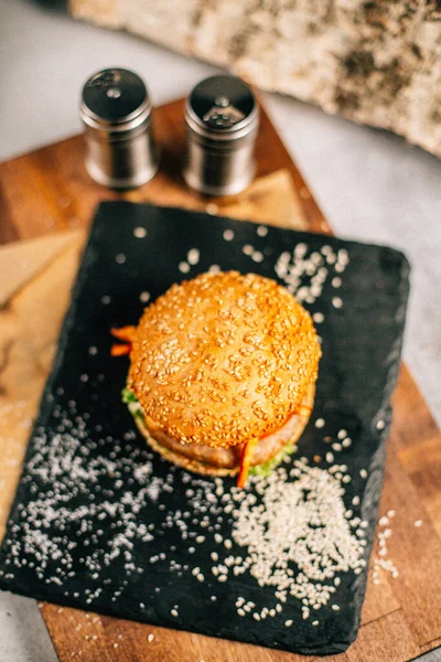 Koyu taş tabakta taze lezzetli bir hamburger, yakın görüş. 