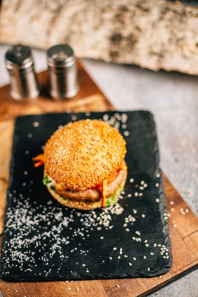 Koyu taş tabakta taze lezzetli bir hamburger, yakın görüş. 