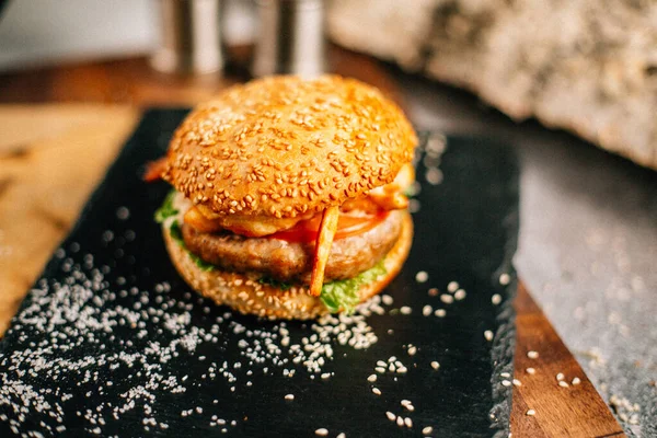 Koyu taş tabakta taze lezzetli bir hamburger, yakın görüş. 