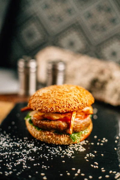 Koyu taş tabakta taze lezzetli bir hamburger, yakın görüş. 