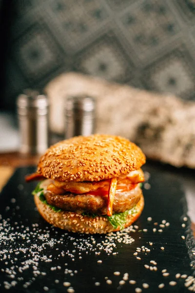Koyu taş tabakta taze lezzetli bir hamburger, yakın görüş. 