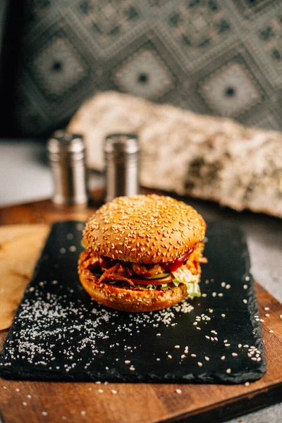 Koyu taş tabakta taze lezzetli bir hamburger, yakın görüş. 