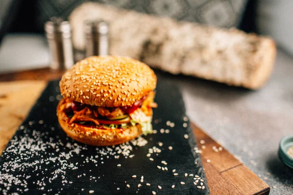 Koyu taş tabakta taze lezzetli bir hamburger, yakın görüş. 