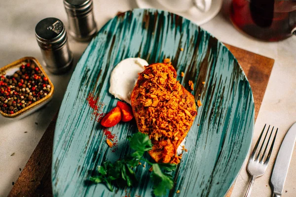 Lezzetli kızarmış et ve ekşi krema soslu vişneli domates ve bir fincan çay ve çaydanlık ile maydanoz. 