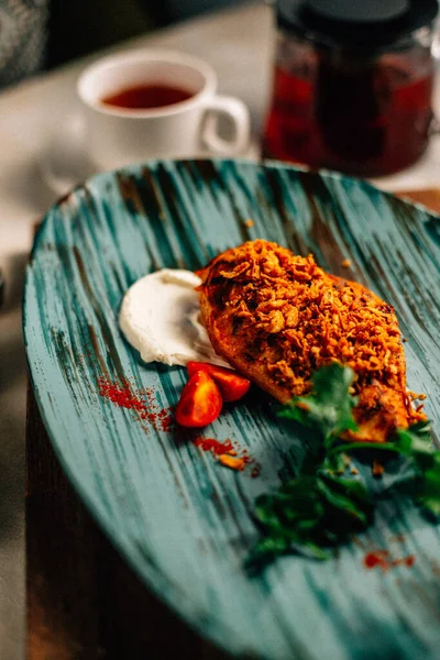 Lezzetli kızarmış et ve ekşi krema soslu vişneli domates ve bir fincan çay ve çaydanlık ile maydanoz. 